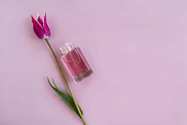 Bovenaanzicht van de compositie met een roze parfumflesje en een bloem het concept van een geschenk dat reclame maakt voor een kopie van de ruimte