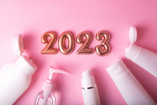 Bovenaanzicht van de cosmeticacontainers op roze achtergrondRose gouden nummers 2023 hierboven