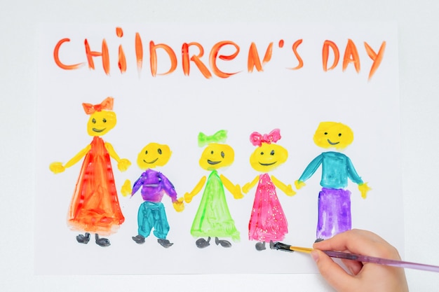 Foto bovenaanzicht van de hand van het kind dat de verschillende kinderen tekent met woorden children's day voor de vakantie happy children's day.