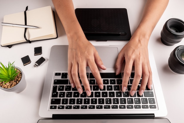 Bovenaanzicht van de handen van een vrouw te typen op een computertoetsenbord