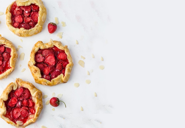 Bovenaanzicht van de minikoekjes met aardbeien Kleine taarten op een witte achtergrond Ruimte voor tekst