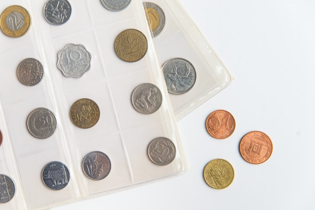 Bovenaanzicht van de numismatische albumbladen en munten. collectie van zeldzame munten op de witte achtergrond met kopie ruimte
