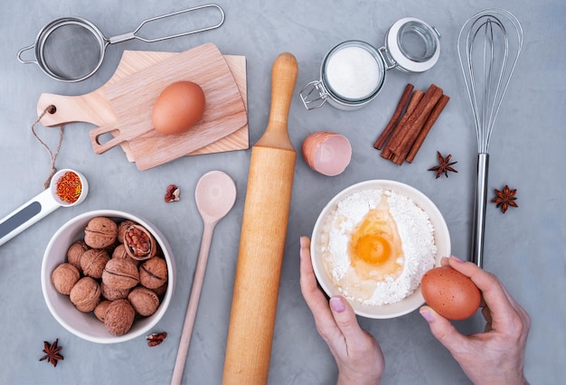 Bovenaanzicht van de werkplek van de banketbakker maakt deeg voor taart. Ingrediënten voor het bakken op grijze ondergrond. Selectieve aandacht.