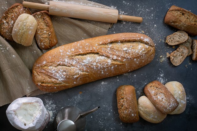 Bovenaanzicht van de werktafel naast de oven met een brood en wat verse broodjes