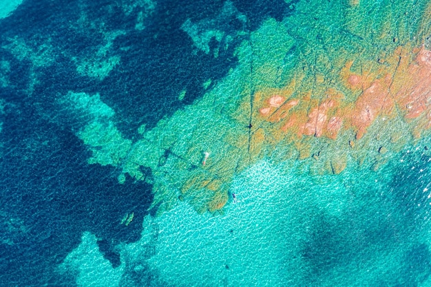 Bovenaanzicht van de zee en het eiland Zeeoppervlak De textuur van water en rotsen