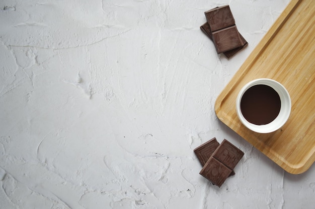 Bovenaanzicht van donkere chocoladevloeistof en snoep op witte achtergrond