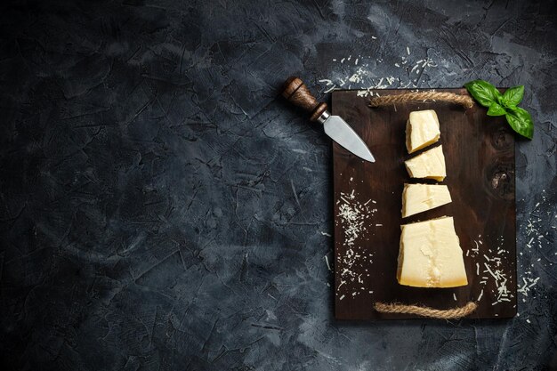 Bovenaanzicht van driehoekig stuk harde kaas op houten snijplank