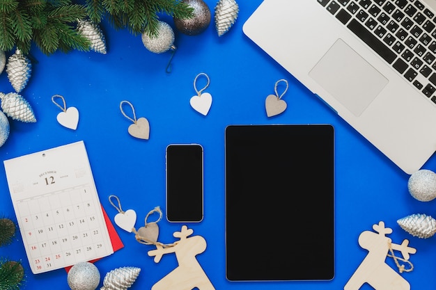 Bovenaanzicht van een blauwe tafel met laptop en kerstdecor