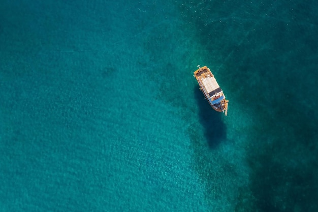 Bovenaanzicht van een boot in ondiep water met schaduw op de zeebodem, Kreta, Griekenland