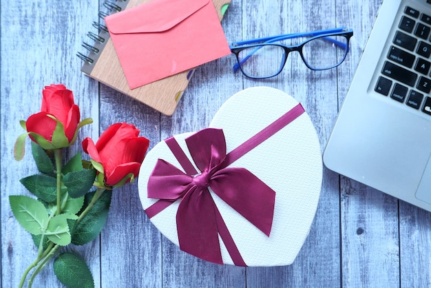 Bovenaanzicht van een hart vorm geschenkdoos en roze bloem op tafel