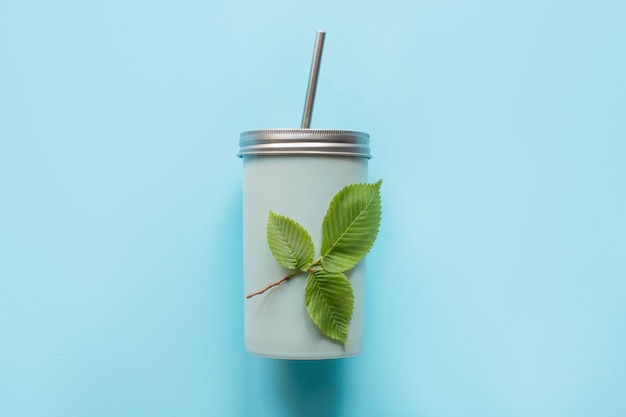 Bovenaanzicht van een herbruikbare pot met een metalen deksel en een rietje voor drankjes in de zomer.