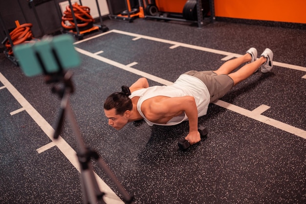 Bovenaanzicht van een knappe dennenman die pushups doet