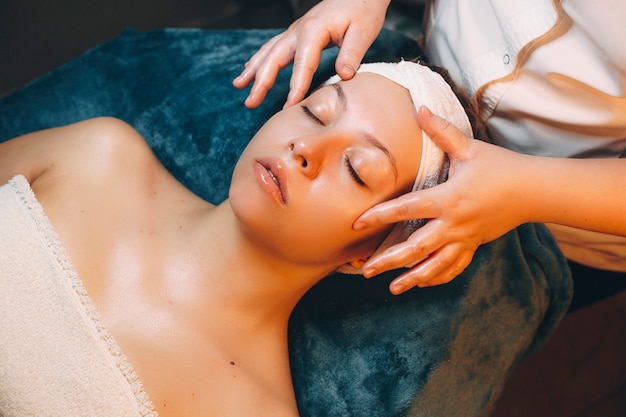 Bovenaanzicht van een leuke vrouw die huidverzorging met hyaluronzuur door een cosmetologie in een wellnessresort doet.