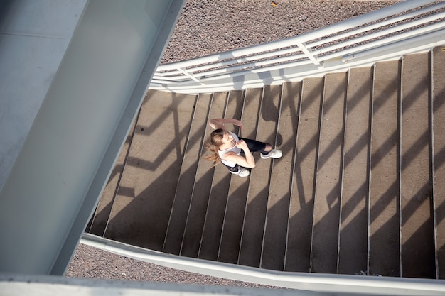 Bovenaanzicht van een meisje dat de trap op rent