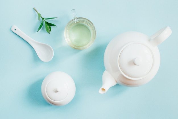 Bovenaanzicht van een set van thee gebruiksvoorwerpen theepot suiker kom beker met thee op een blauwe ondergrond
