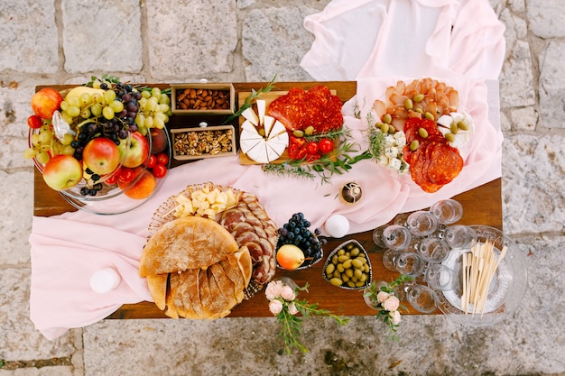 Bovenaanzicht van een tafel met lekkernijen voor de viering en lege glazen voor champagne