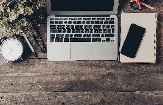 Bovenaanzicht van een thuiskantoor werkplek op een oude houten tafel met laptop