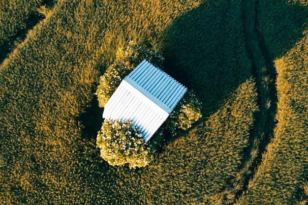 Bovenaanzicht van een verlaten huis midden in een veld