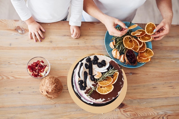 Bovenaanzicht van een vrouw met haar kleindochter die dieetcake op de keuken voorbereidt