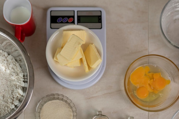 Bovenaanzicht van een weegschaal met boter en andere ingrediënten om brood te bereiden