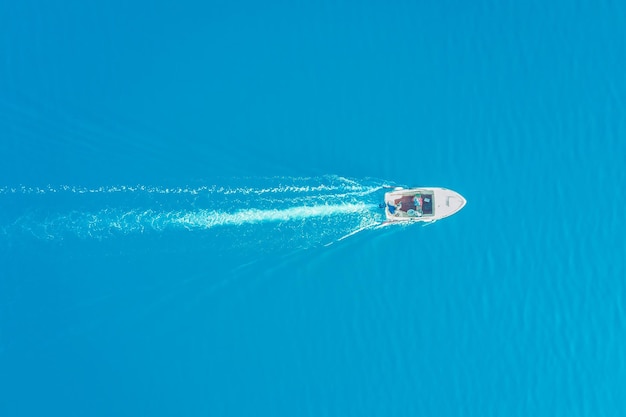 Foto bovenaanzicht van een witte boot die in de blauwe zee vaart