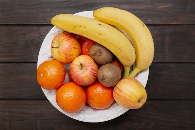 Bovenaanzicht van fruit in een kom op houten tafel. gezond eten concept