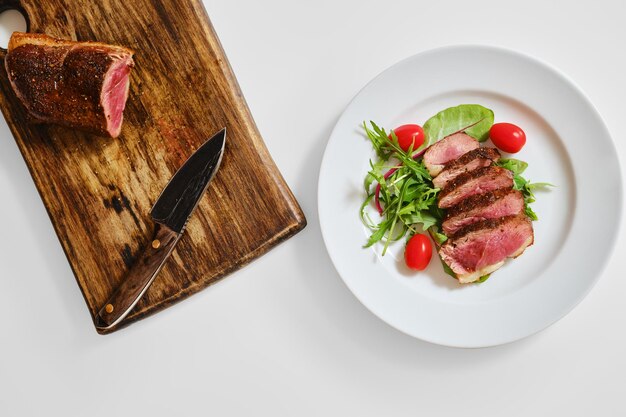 Bovenaanzicht van gebakken eendenborst medium rare geserveerd op een bord