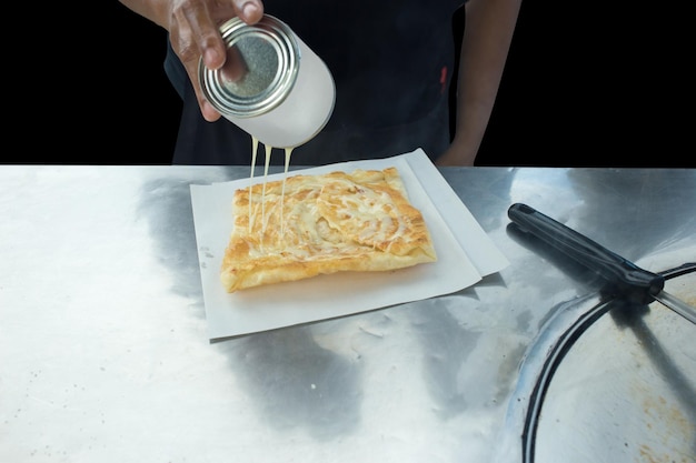 Bovenaanzicht van gebakken heerlijke Roti-topping met selectieve melkfocus