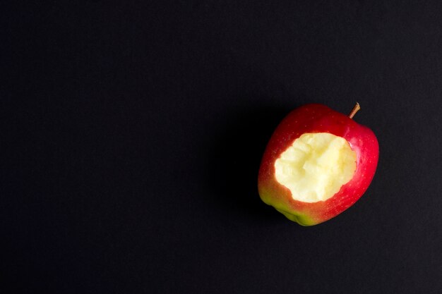 Bovenaanzicht van gebeten appel op een zwarte achtergrond. Ruimte kopiëren. Natuurlijk eten.