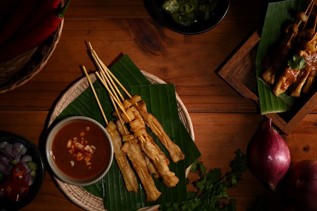 Bovenaanzicht van gegrilde varkenssaté (Moo Satay) geserveerd met pindasaus