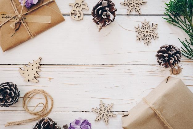 Bovenaanzicht van geschenkdoos en kerstkaart op houten tafel met xmas decoratie.