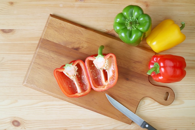 Bovenaanzicht van gesneden rode paprika op een snijplank met mes