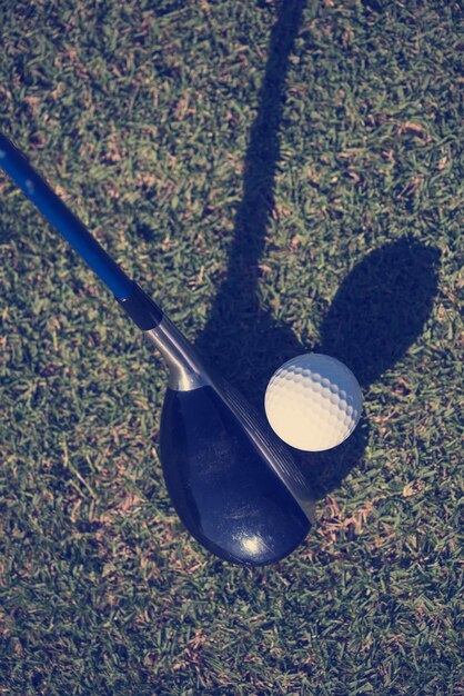 Foto bovenaanzicht van golfclub en bal in gras op baan die zich voorbereidt op schot