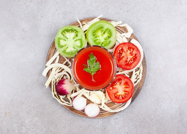 Bovenaanzicht van groene en rode tomatenplakken met radijs op houten oppervlak.