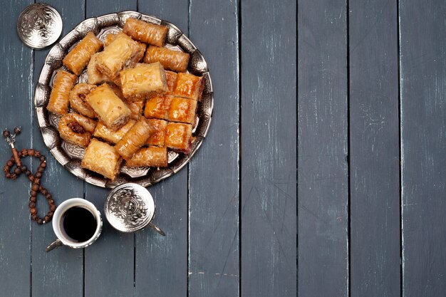 Bovenaanzicht van grote metalen dienblad met Turkse baklava op planked houten tafel