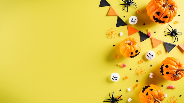 Bovenaanzicht van Halloween-ambachten, oranje pompoen, spook, vleermuis en zwarte spin