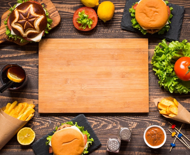 Bovenaanzicht van heerlijke hamburger, met groenten, op een houten achtergrond.