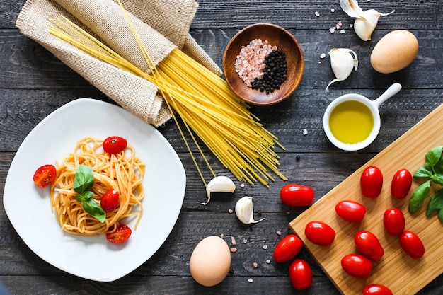 Bovenaanzicht van Italiaanse ingrediënten voor tomaat en basilicum spaghetti.