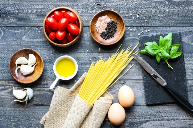 Bovenaanzicht van Italiaanse ingrediënten voor tomaat en basilicum spaghetti.