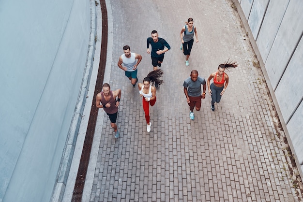 Bovenaanzicht van jonge mensen in sportkleding die joggen terwijl ze buiten sporten