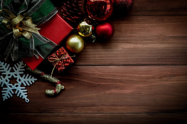 Foto bovenaanzicht van kerstmis achtergrond met ornamenten en geschenkdozen op de oude houten bord.