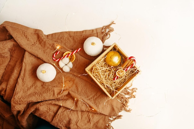 Bovenaanzicht van kerstsamenstelling bruine warme deken en geschenkdoos met nieuwjaar gouden bal lolly...