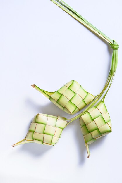 Bovenaanzicht van Ketupat geïsoleerd op een witte achtergrond. typisch gerecht gemaakt van rijst verpakt in wikkels gemaakt van gevlochten jonge kokosbladeren.
