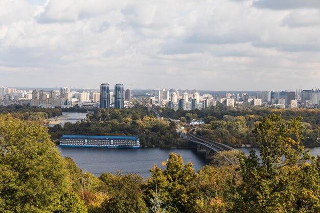 Bovenaanzicht van Kiev vanaf het Peremogy-park. Uitzicht op de stad Kiev en de rivier de Dnjepr. Stadspanorama met een brug over de rivier