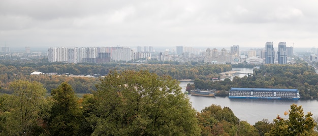 Bovenaanzicht van Kiev vanaf het Peremogy-park. Uitzicht op de stad Kiev en de rivier de Dnjepr. Stadspanorama met een brug over de rivier