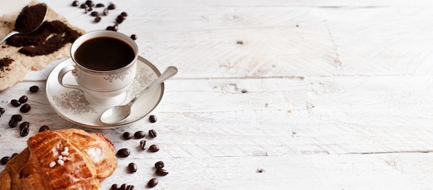 Bovenaanzicht van koffie met croissant op rustiek wit hout