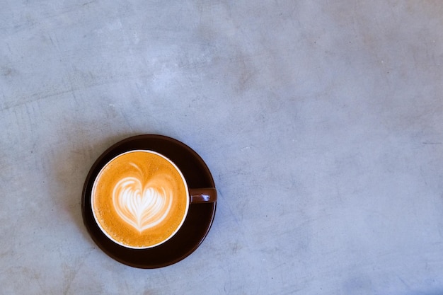 Bovenaanzicht van kopje cappuccino met mooie latte art op concrete achtergrond