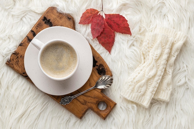 Bovenaanzicht van kopje koffie met herfstblad en lepel