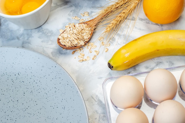 Bovenaanzicht van lege grijze plaat en verse, gezonde fruiteieren op ijsachtergrond