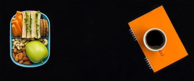 Bovenaanzicht van lunchbox koffiekopje en oranje notitieboekje op de zwarte achtergrond Kopieer ruimte